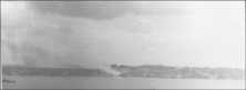 (détails) Le pied de la descente de Vierville sous le feu des obus de 356mm du "Texas" vers 13h00. Le clocher n'est pas encore détruit, on distingue le château mais sans