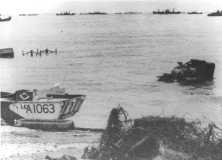 (details) On June 7, the wreckage of one of the B/116 ACLs, was hard tested the day before. To the right, a drowned Sherman tank. On the left, two typical "C" obstacles emerge. At larg