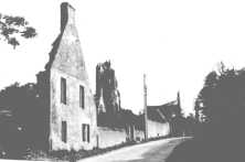 (détails) la maison des Collières et l'église ruinée en arrière-plan