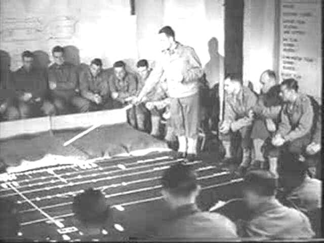 Briefing des Américains devant un maquette qui semble représenter la descente E3 (Colleville) Photo aérienne du 27 avril 1944, le WN62 est à droite sur la photo
