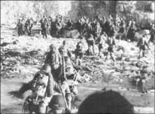 (détails) Des GI débarquent, à l'abri de la vue des Allemands, au pied de la falaise, à mer haute (détails) Vers 11h00, le LCI 83 amène des renforts de soldats sur Fox Gr