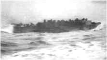 Un LCVP chargé de fantassins Sortie des hommes par l'avant du LCVP, ils se dirigent vers la plage étroite déjà occupée