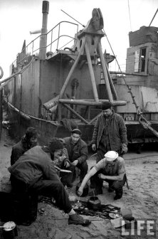 (details) A GMC truck in front of the wreckage of a LCVP. (details) A dead sailor on his boat. (details) Summary meals on the beach (details)