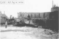 Al Jones, marin de la Navy, devant un LCT endommagé par une mine