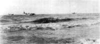 (détails) Le LCT 603 décharge des Jeep qui avancent malaisément sur les gros galets (détails) (détails) Sous les vagues une jeep de "medics" s'est noyée