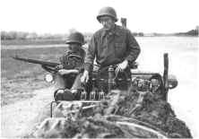 (détails) Un motorgrader (nivelleuse) au travail, le conducteur est assisté d'un tireur le protégeant des snipers (détails) Approvisionnement et mise en place de grillage