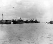 (détails) La digue vue du large, à droite le LST212 vu de l'arrière (détails) remarquer les LCM à couple d'un cargo sabordé qui doit servir de casernement pour les équipa
