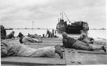 (détails) Un causeway en construction Un LCT approche d'un causeway, mais des chasseurs-bombardiers Allemands inquiètent les GI qui s'aplatissent à terre Marins travailla