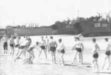 Des GI font du sport en attendant que la mer se retire suffisamment pour que le déchargement des LST commence
