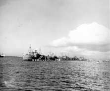 (détails) La digue vue du large, à droite le LST212 vu de l'arrière (détails) remarquer les LCM à couple d'un cargo sabordé qui doit servir de casernement pour les équipa